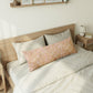 Bedroom with a wooden bed frame and white bedding, featuring a decorative pillow.