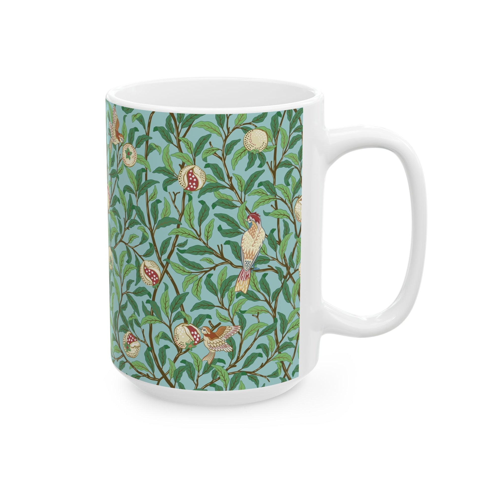 A ceramic mug with a blue background featuring a floral pattern of birds and pomegranates.