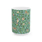 A ceramic mug with a blue background featuring a floral pattern of birds and pomegranates.