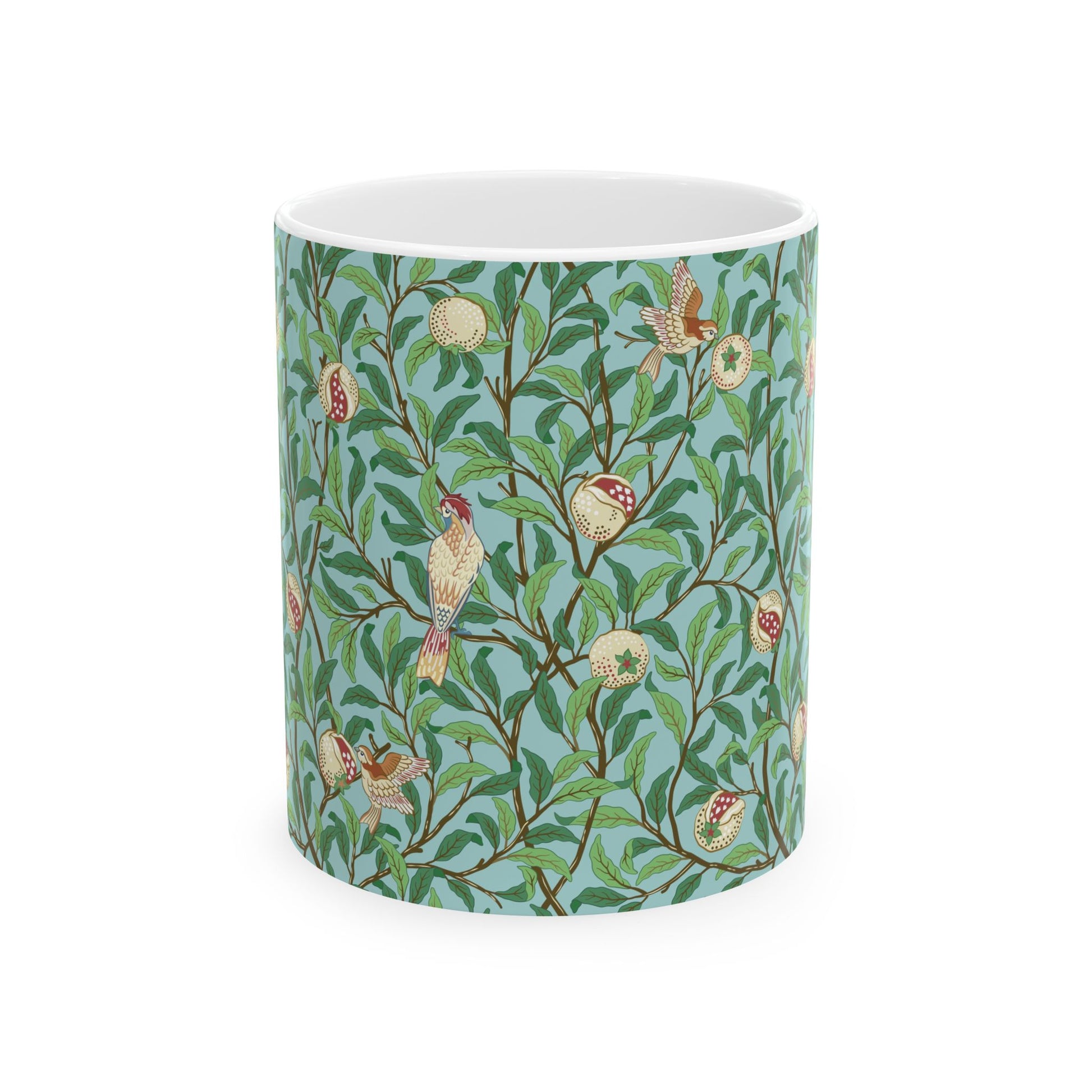 A ceramic mug with a blue background featuring a floral pattern of birds and pomegranates.