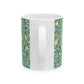 A ceramic mug with a blue background featuring a floral pattern of birds and pomegranates.