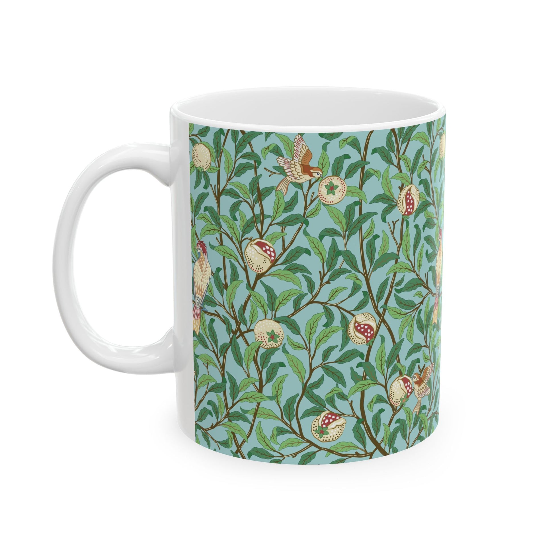 A ceramic mug with a blue background featuring a floral pattern of birds and pomegranates.