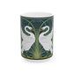A ceramic mug with a design of two white swans on a green and blue background, inspired by the art of William Morris.