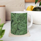 A ceramic mug with a green and white leaf pattern inspired by William Morris - Acanthus Collection.