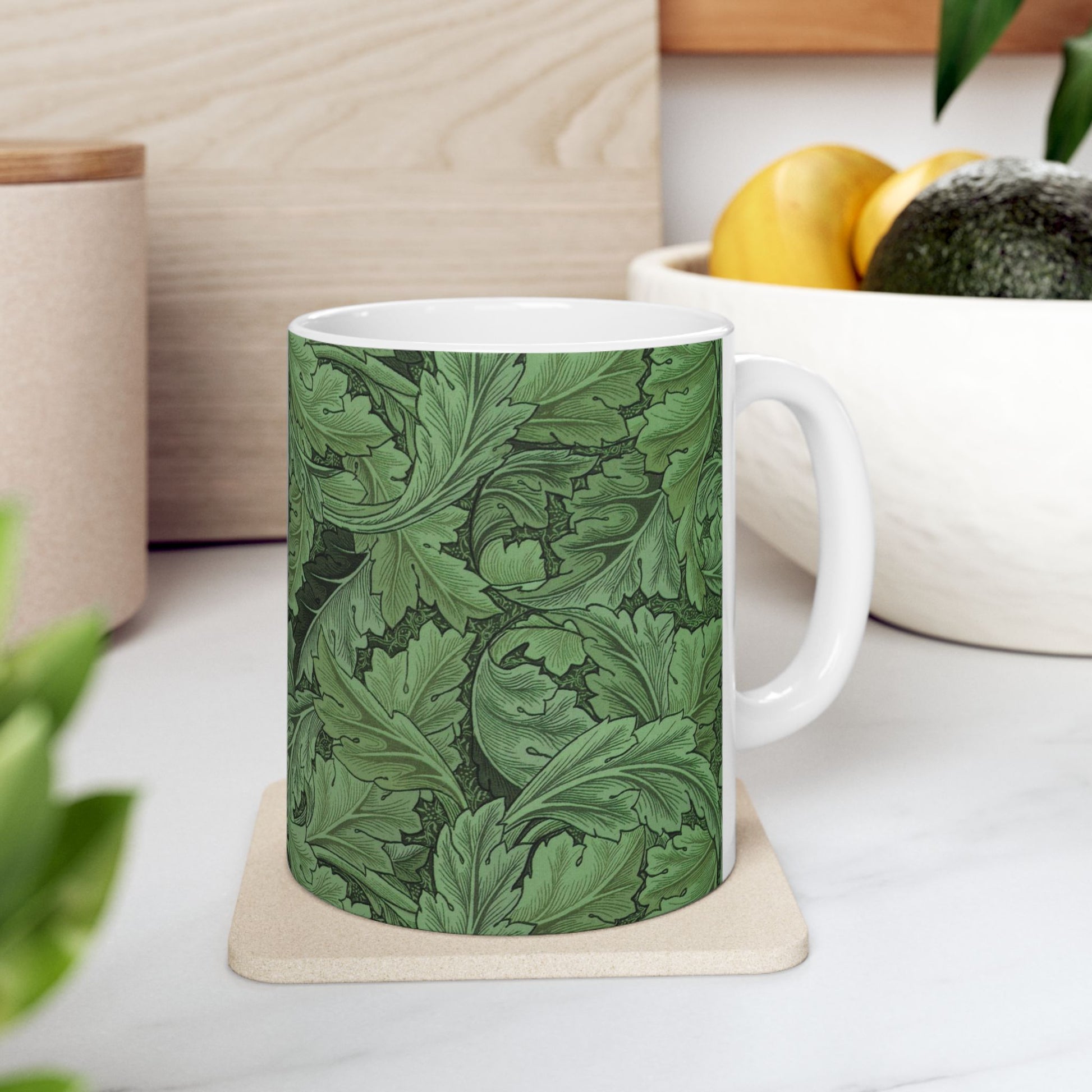 A ceramic mug with a green and white leaf pattern inspired by William Morris - Acanthus Collection.