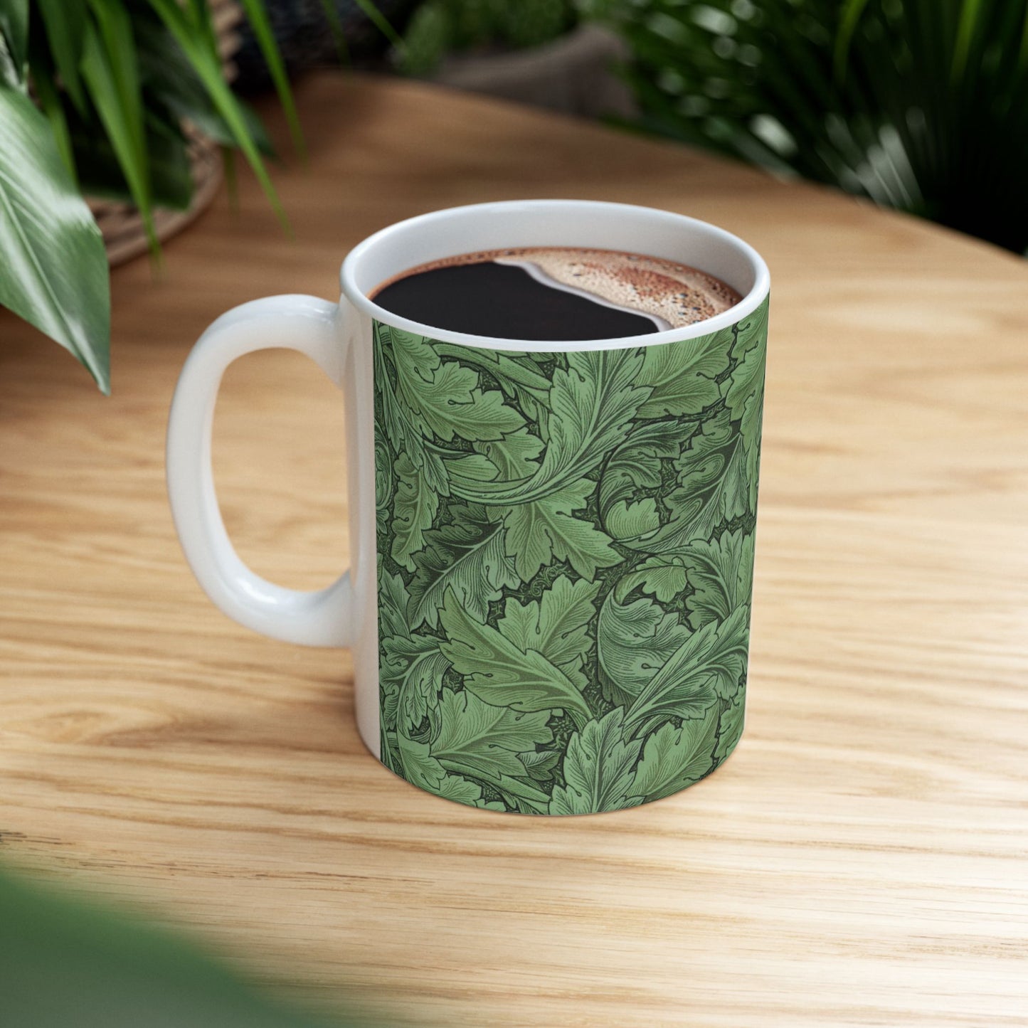 A ceramic mug with a green and white leaf pattern inspired by William Morris - Acanthus Collection.