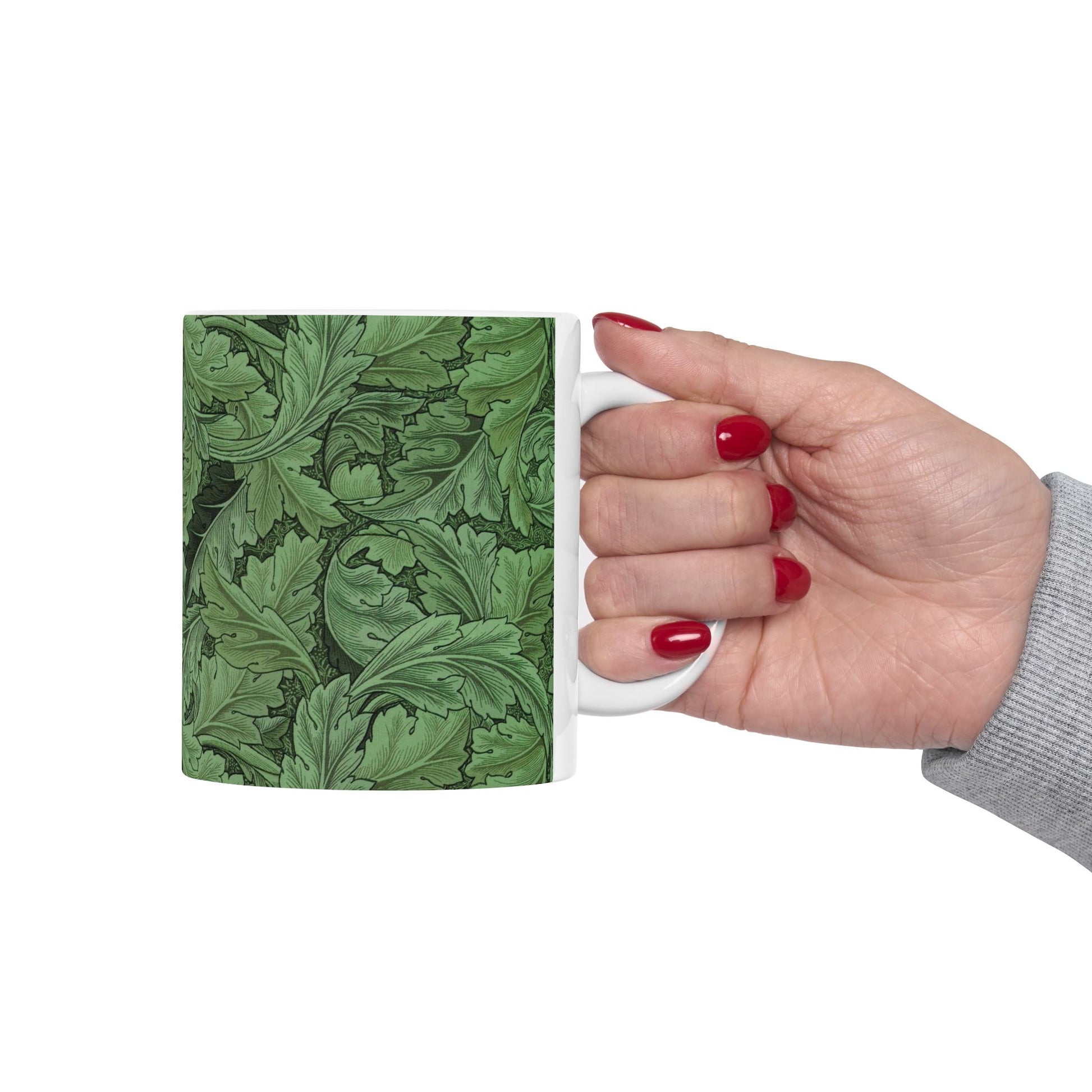 A ceramic mug with a green and white leaf pattern inspired by William Morris - Acanthus Collection.