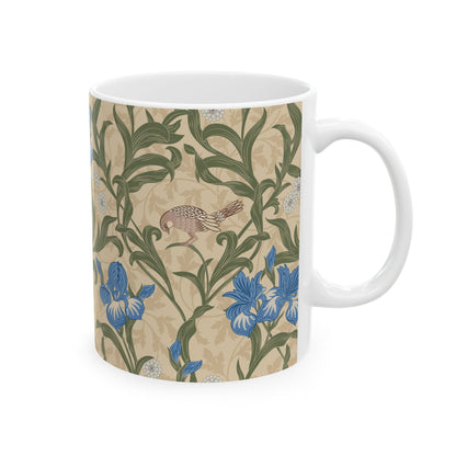 A ceramic mug with a floral William Morris & Co pattern design, featuring a bird and various flowers in shades of blue, green and beige.