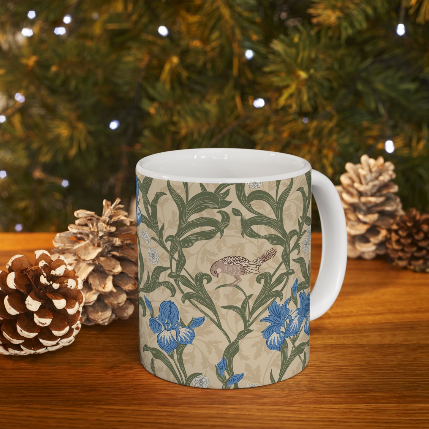 A ceramic mug with a floral William Morris & Co pattern design, featuring a bird and various flowers in shades of blue, green and beige.