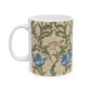 A ceramic mug with a floral William Morris & Co pattern design, featuring a bird and various flowers in shades of blue, green and beige.