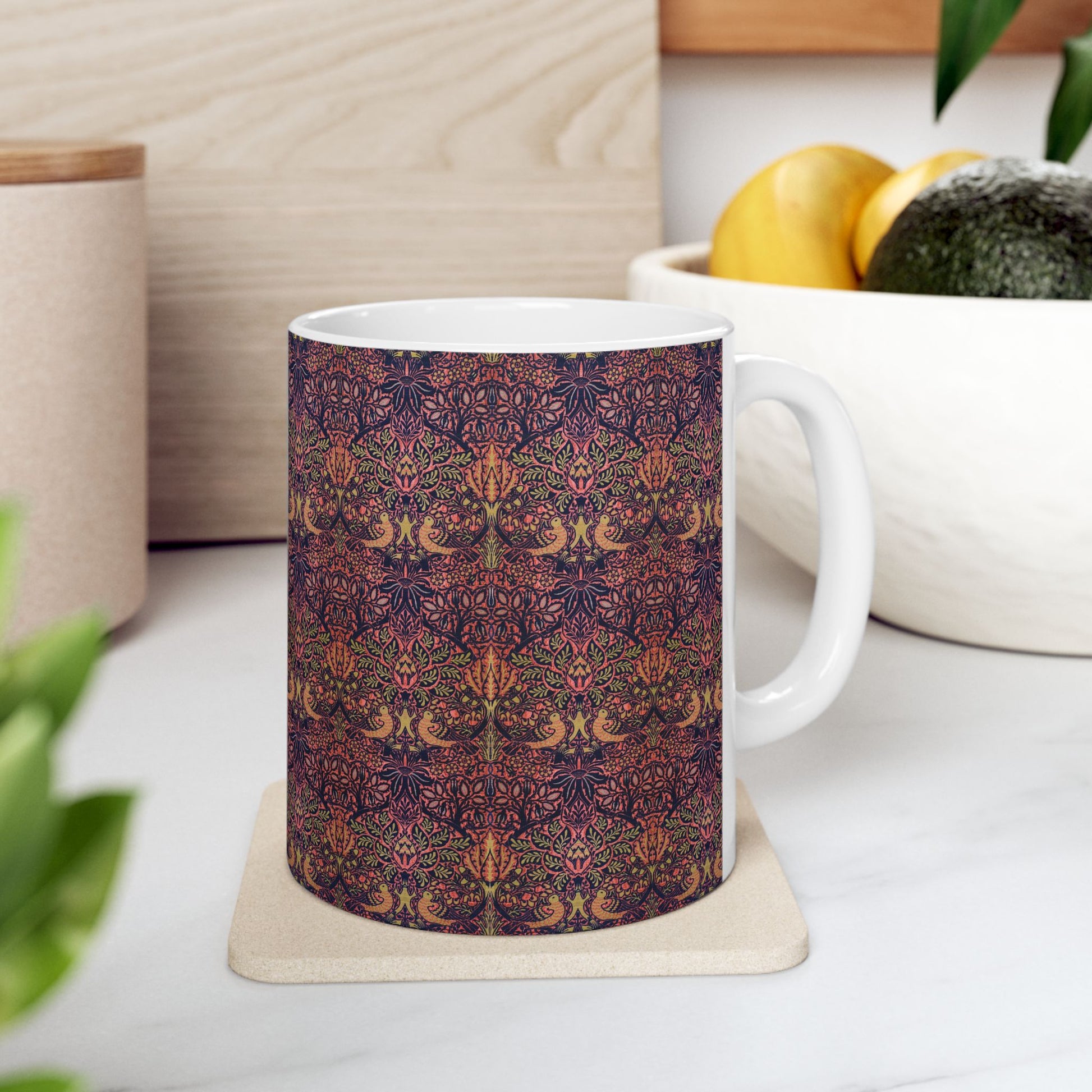 A ceramic mug with a floral pattern inspired by William Morris's artistry, featuring a white base and a shiny finish.