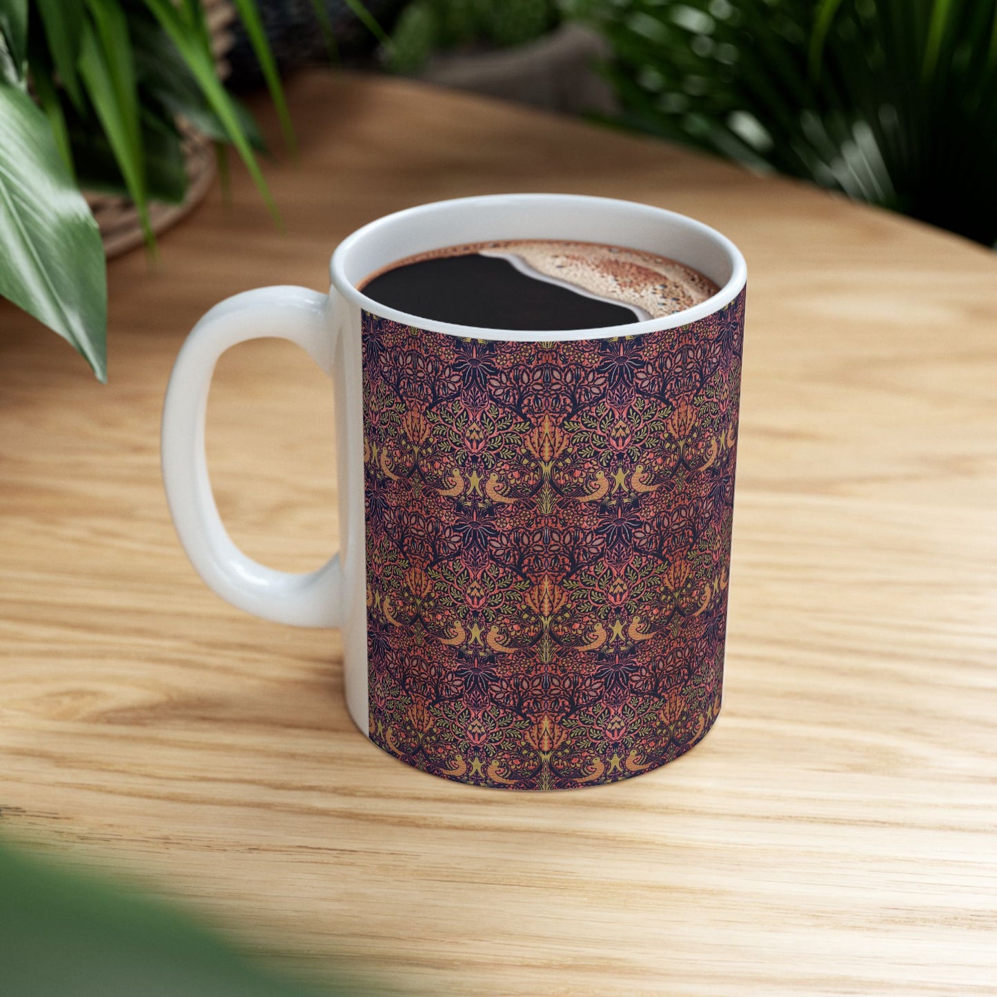 A ceramic mug with a floral pattern inspired by William Morris's artistry, featuring a white base and a shiny finish.