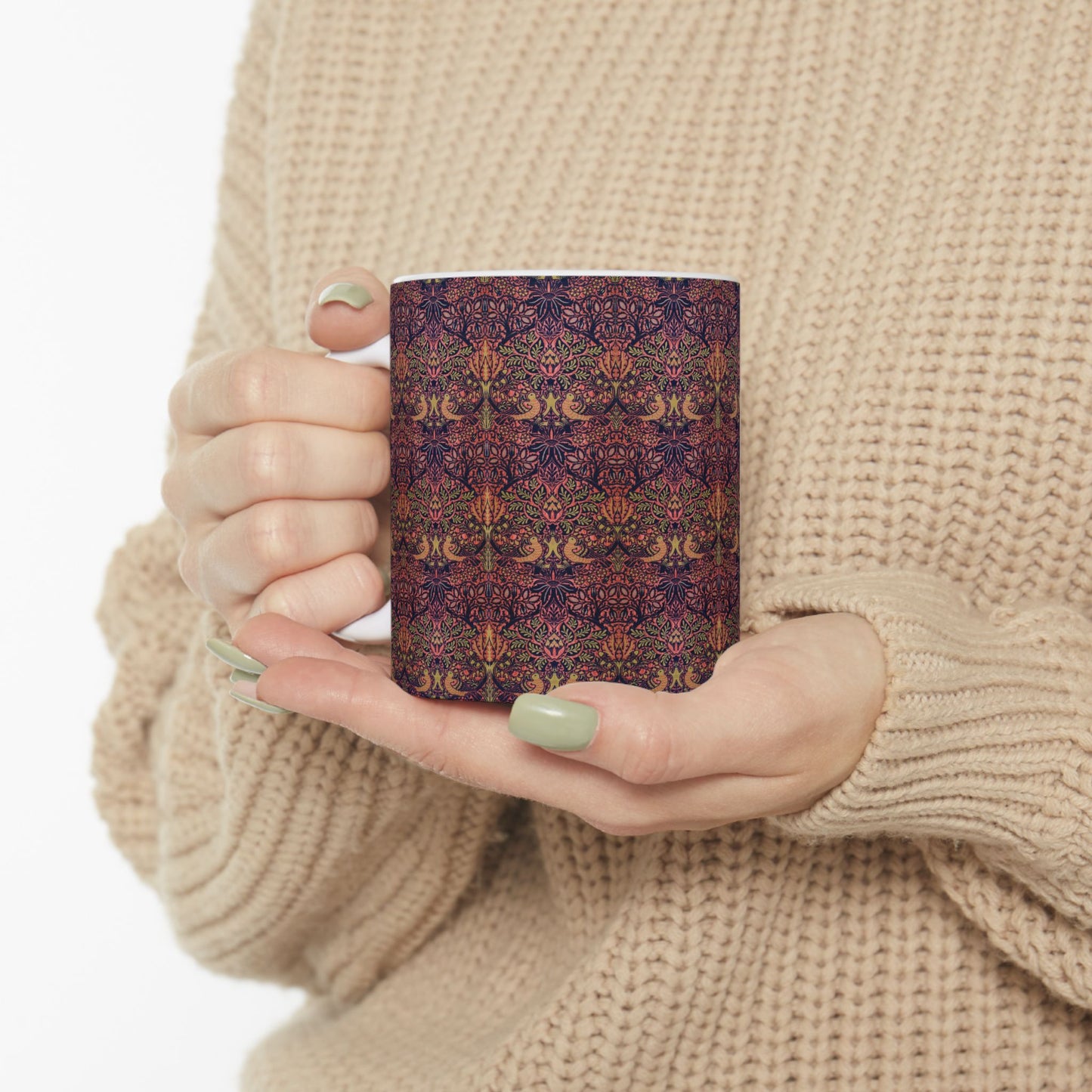 A ceramic mug with a floral pattern inspired by William Morris's artistry, featuring a white base and a shiny finish.