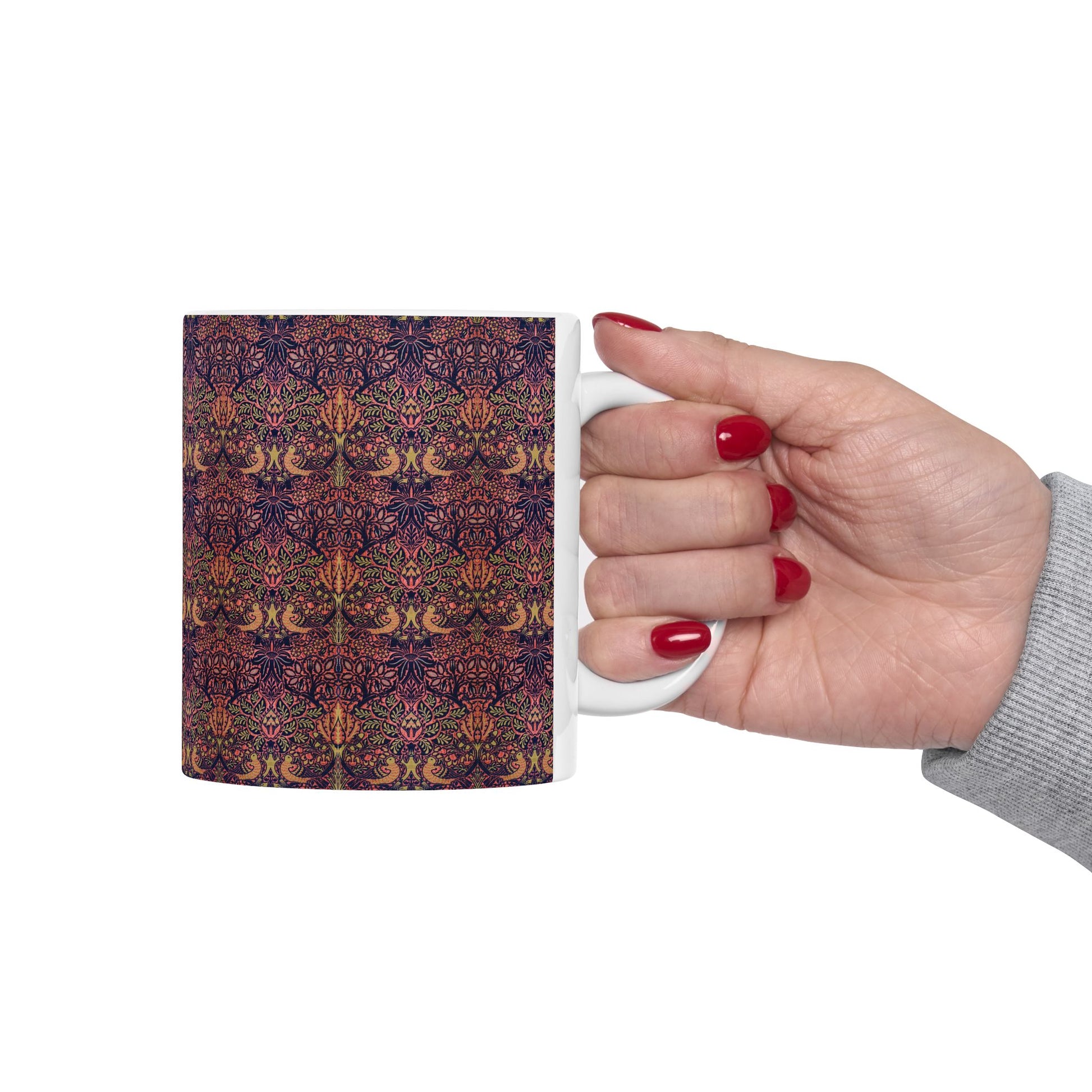 A ceramic mug with a floral pattern inspired by William Morris's artistry, featuring a white base and a shiny finish.