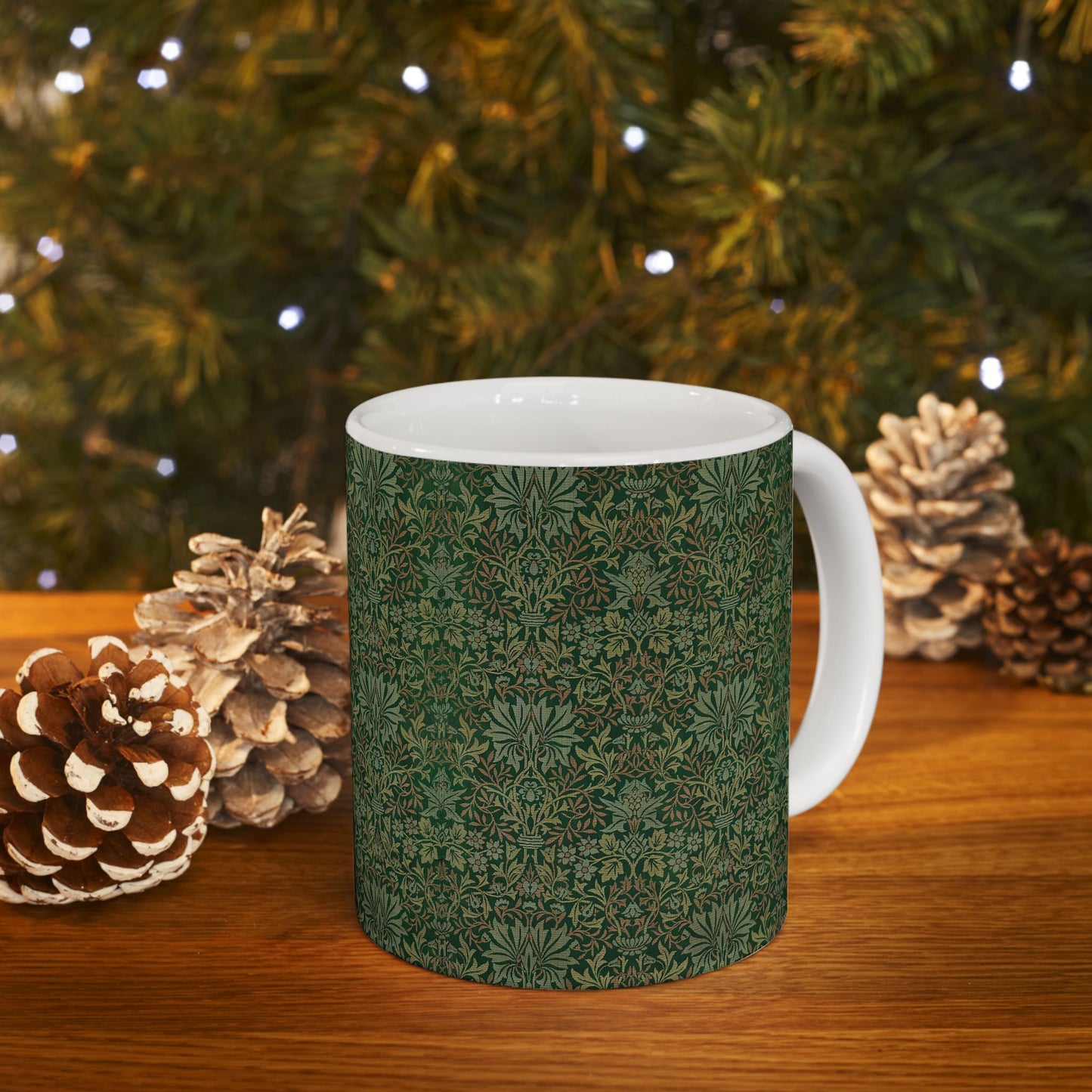 A ceramic mug with a floral garden William Morris & Co pattern design, predominantly green and white.