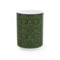 A ceramic mug with a floral garden William Morris & Co pattern design, predominantly green and white.