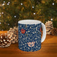 A ceramic mug with a floral pattern and a white handle featuring a blue. white, red and pink pattern design called Medway by William Morris & Co