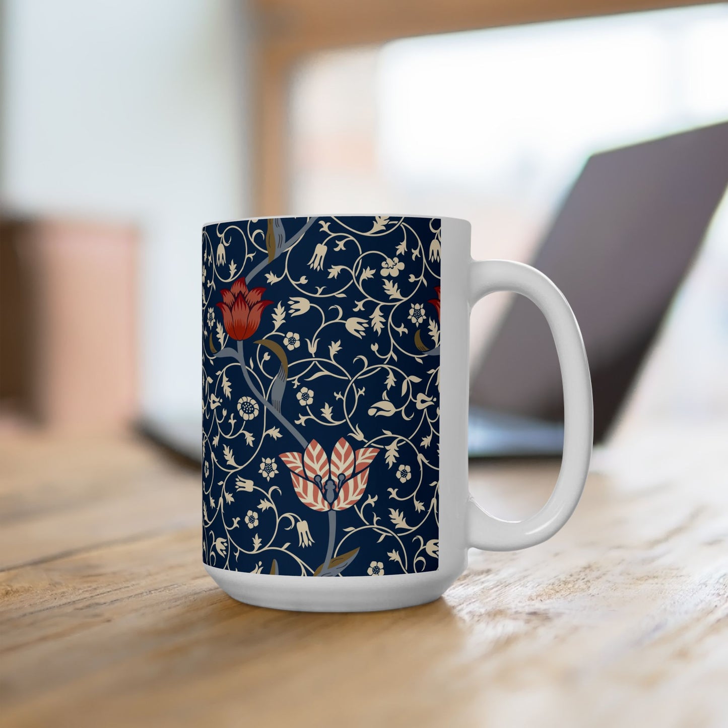 A ceramic mug with a floral pattern and a white handle featuring a blue. white, red and pink pattern design called Medway by William Morris & Co
