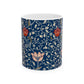 A ceramic mug with a floral pattern and a white handle featuring a blue. white, red and pink pattern design called Medway by William Morris & Co