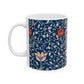 A ceramic mug with a floral pattern and a white handle featuring a blue. white, red and pink pattern design called Medway by William Morris & Co