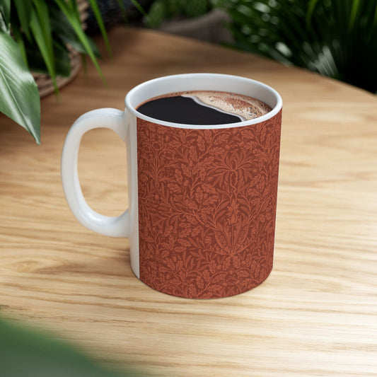 A ceramic mug with a rust-coloured floral pattern inspired by William Morris - Acorns & Oak Leaves Collection.