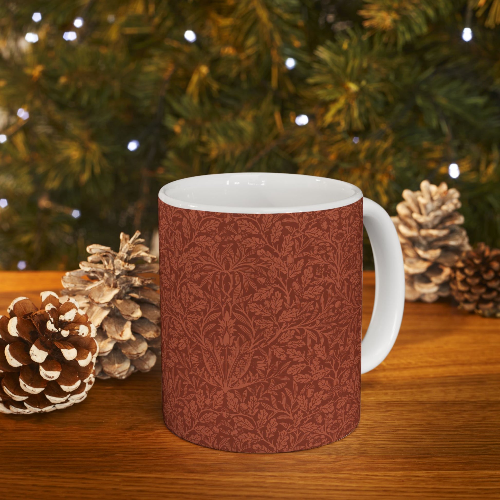 A ceramic mug with a rust-coloured floral pattern inspired by William Morris - Acorns & Oak Leaves Collection.