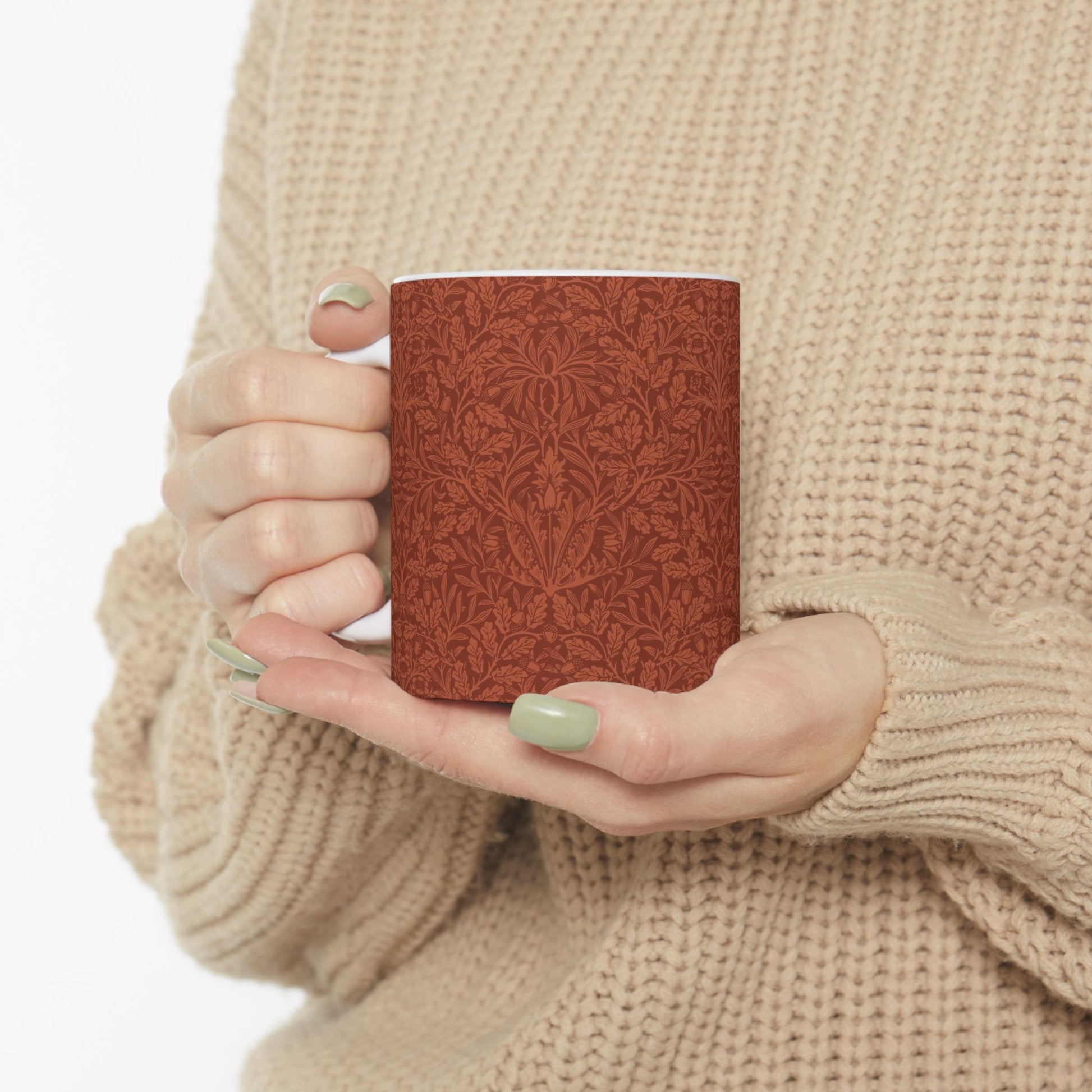A ceramic mug with a rust-coloured floral pattern inspired by William Morris - Acorns & Oak Leaves Collection.