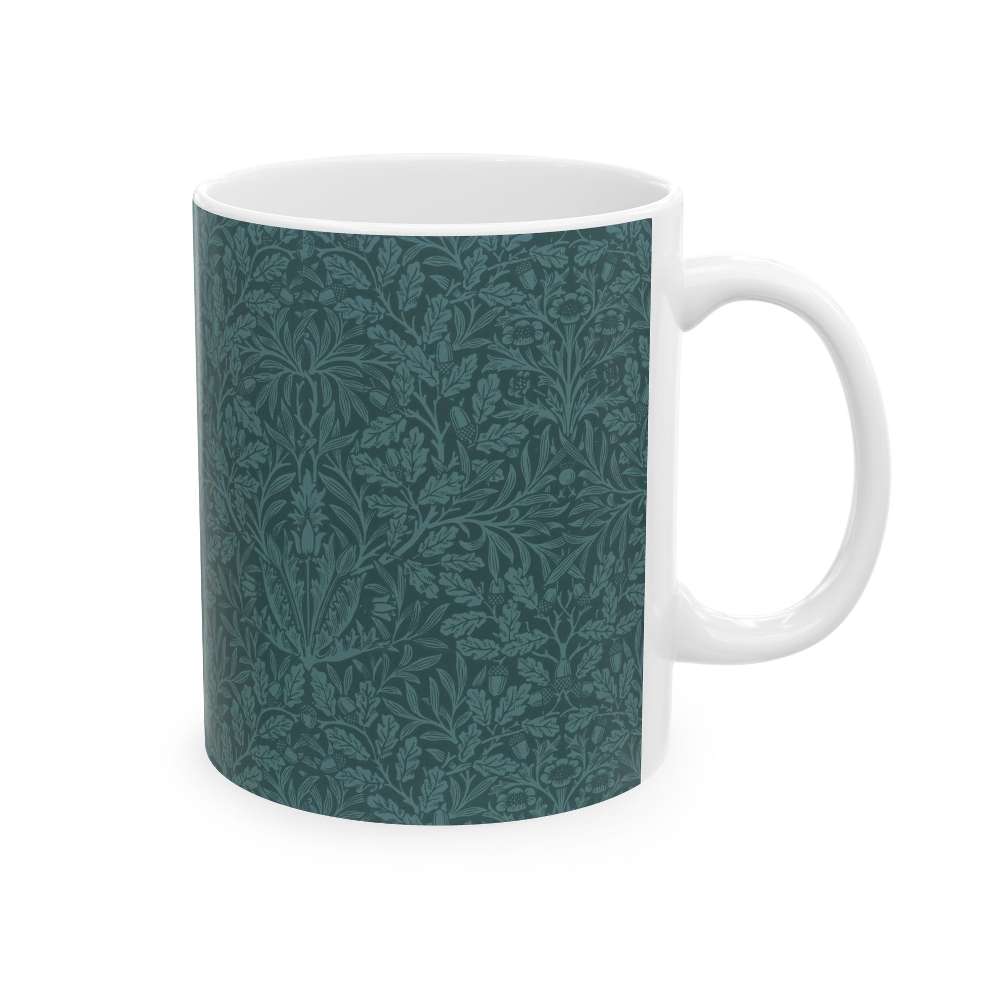 A ceramic mug with a teal base and a white handle featuring a floral and acorn pattern design, inspired by William Morris.