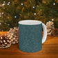 A ceramic mug with a teal base and a white handle featuring a floral and acorn pattern design, inspired by William Morris.