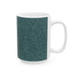 A ceramic mug with a teal base and a white handle featuring a floral and acorn pattern design, inspired by William Morris.