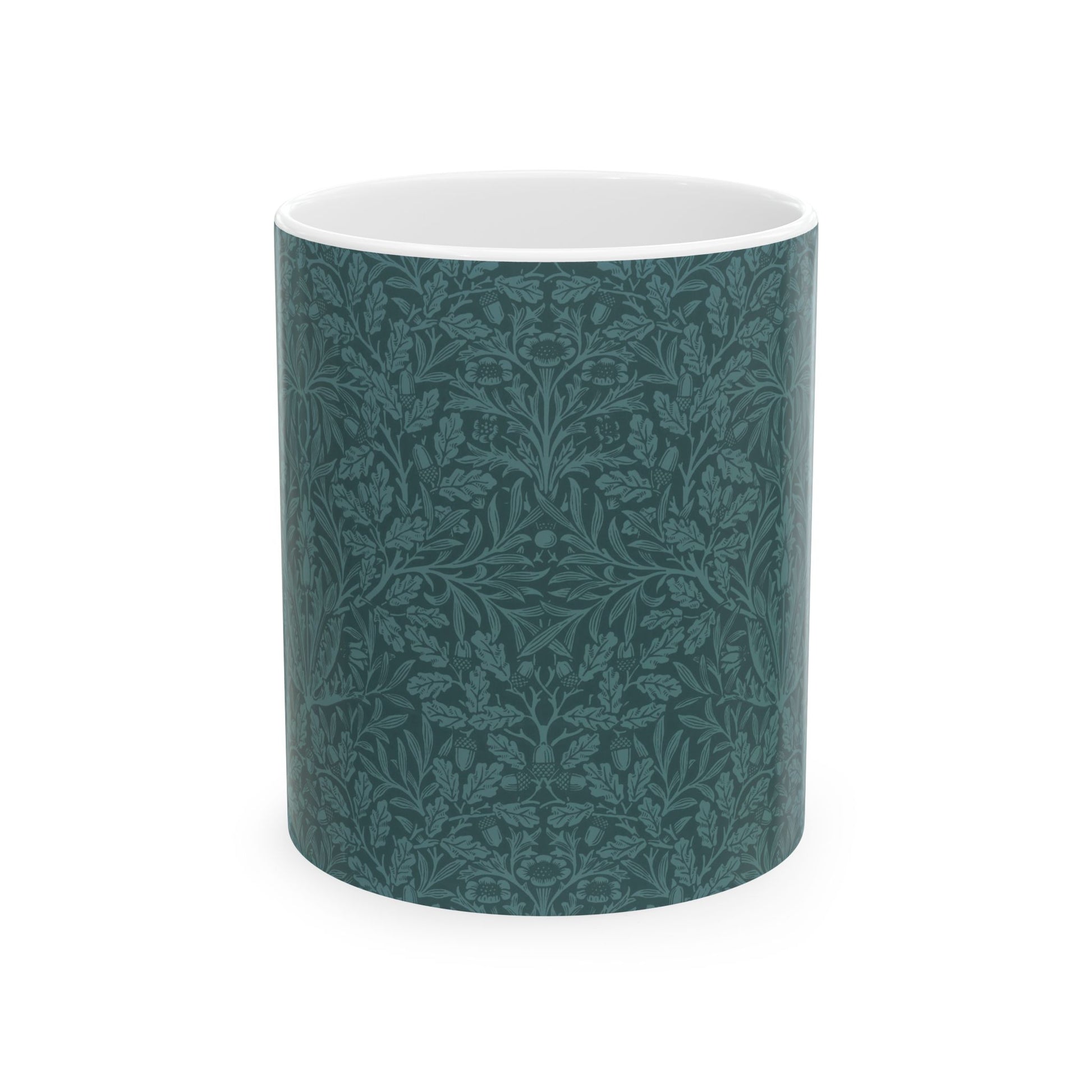 A ceramic mug with a teal base and a white handle featuring a floral and acorn pattern design, inspired by William Morris.