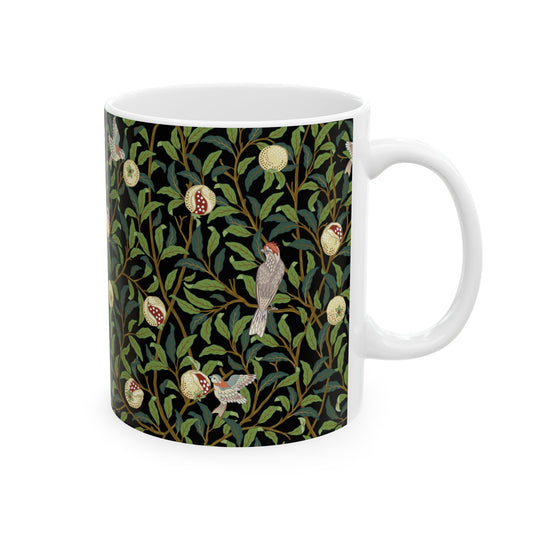 A ceramic mug with a black background featuring a floral William Morris & Co pattern of birds and pomegranates.