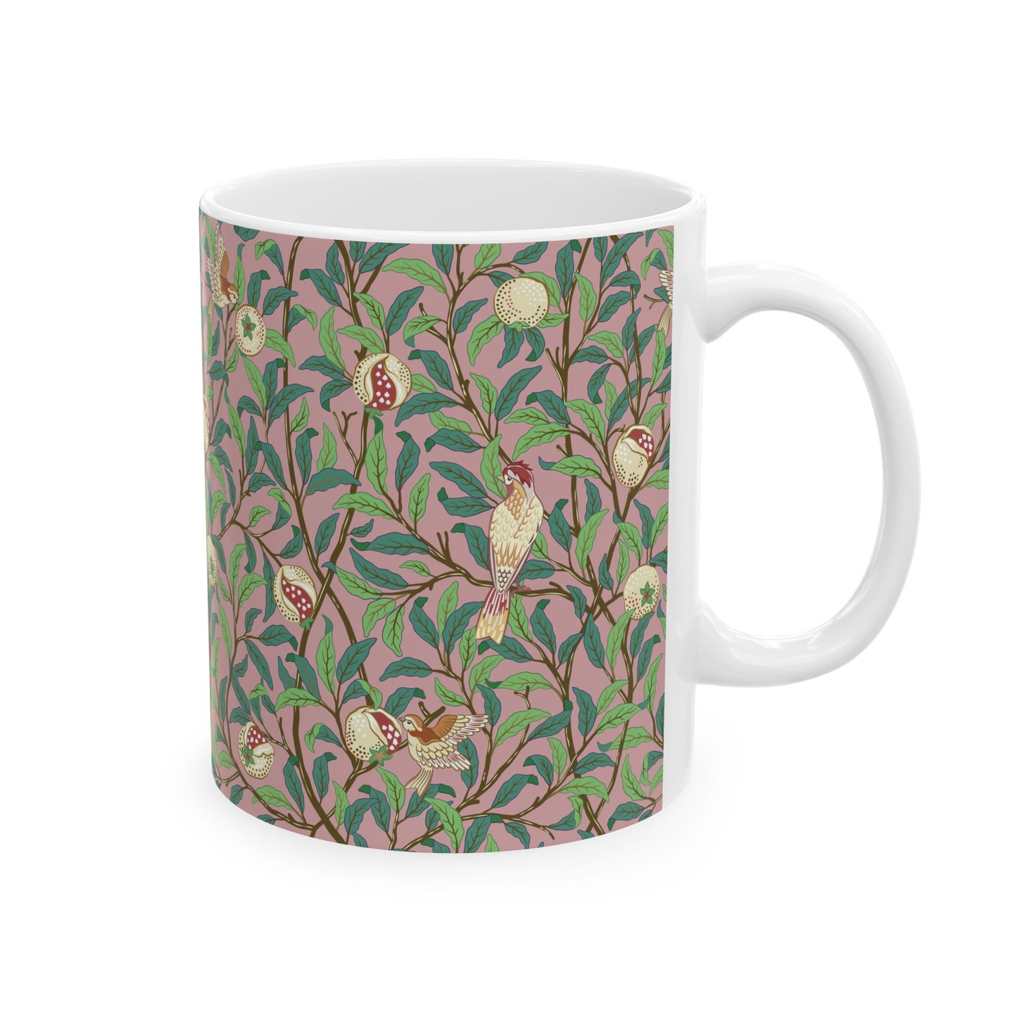 A white ceramic mug with a pink floral and pomegranate design inspired by William Morris.