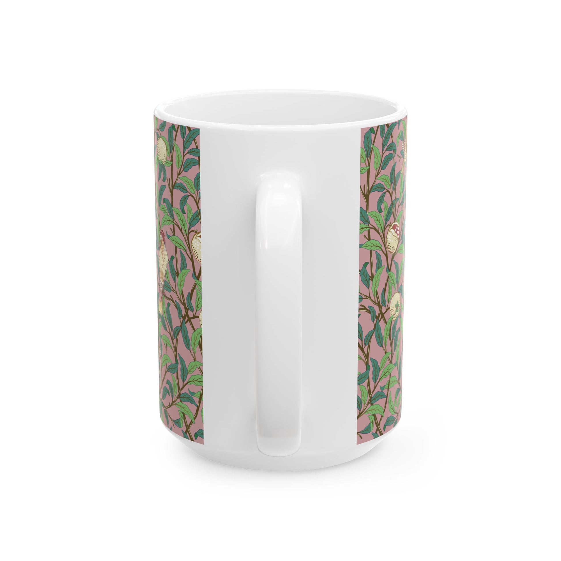 A white ceramic mug with a pink floral and pomegranate design inspired by William Morris.
