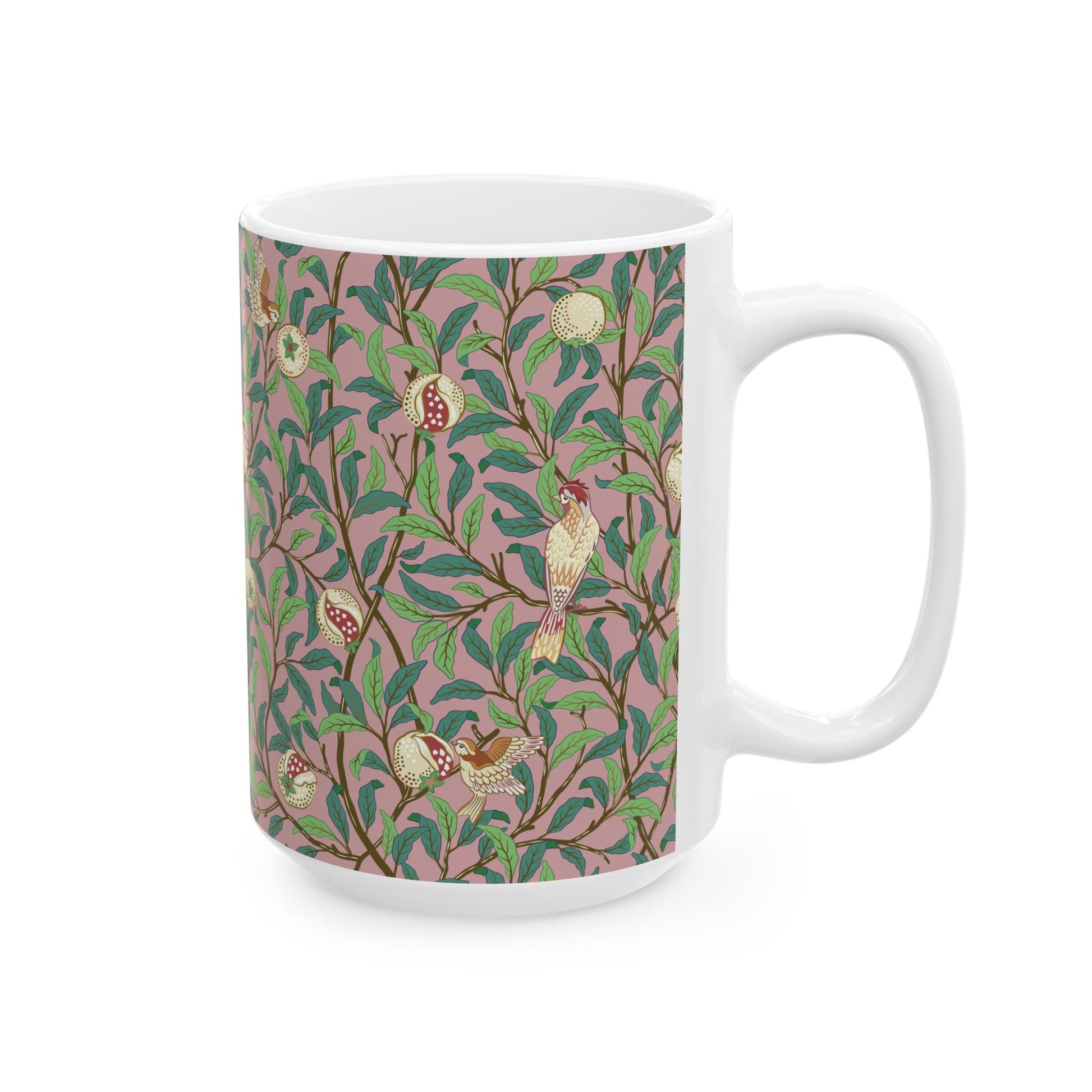 A white ceramic mug with a pink floral and pomegranate design inspired by William Morris.