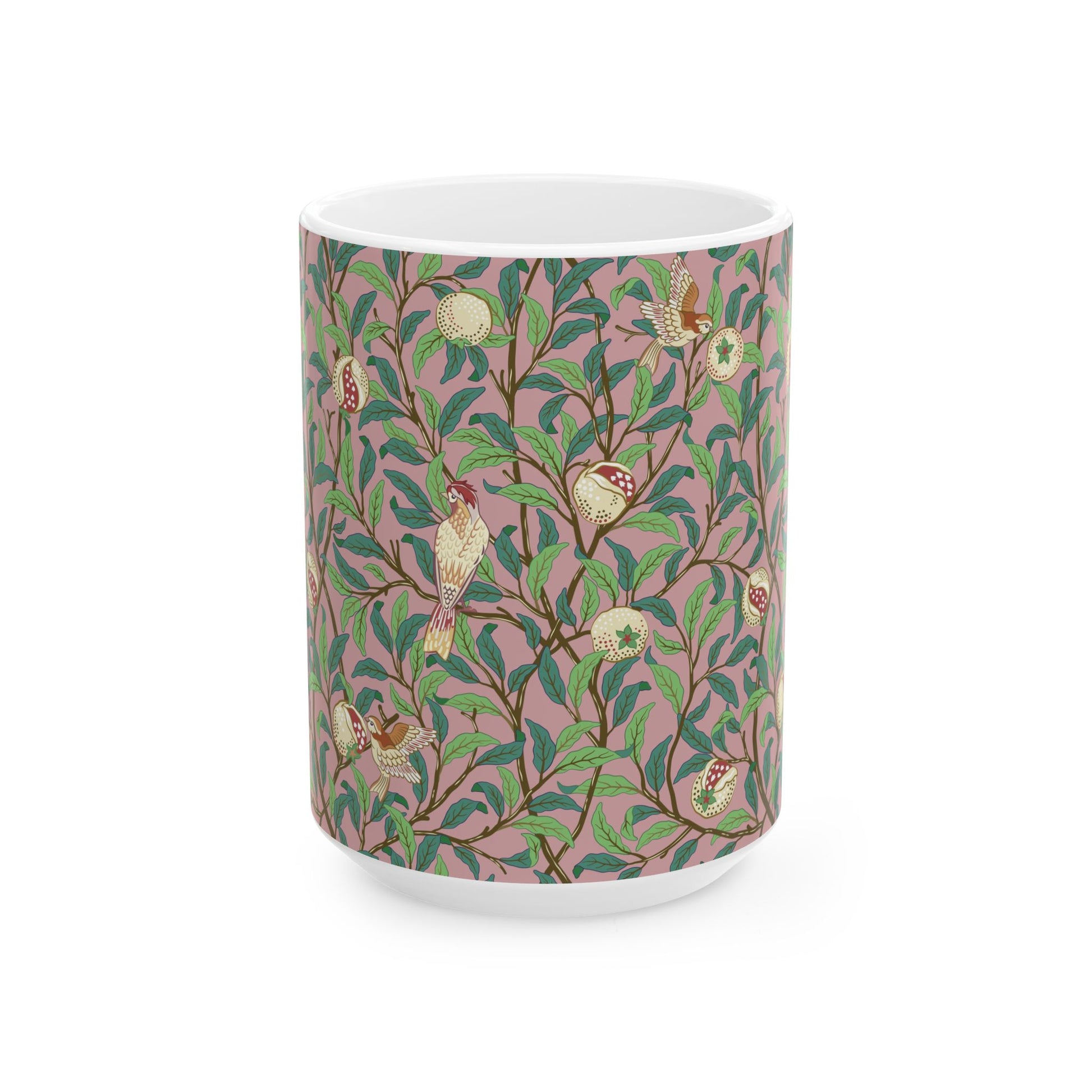 A white ceramic mug with a pink floral and pomegranate design inspired by William Morris.