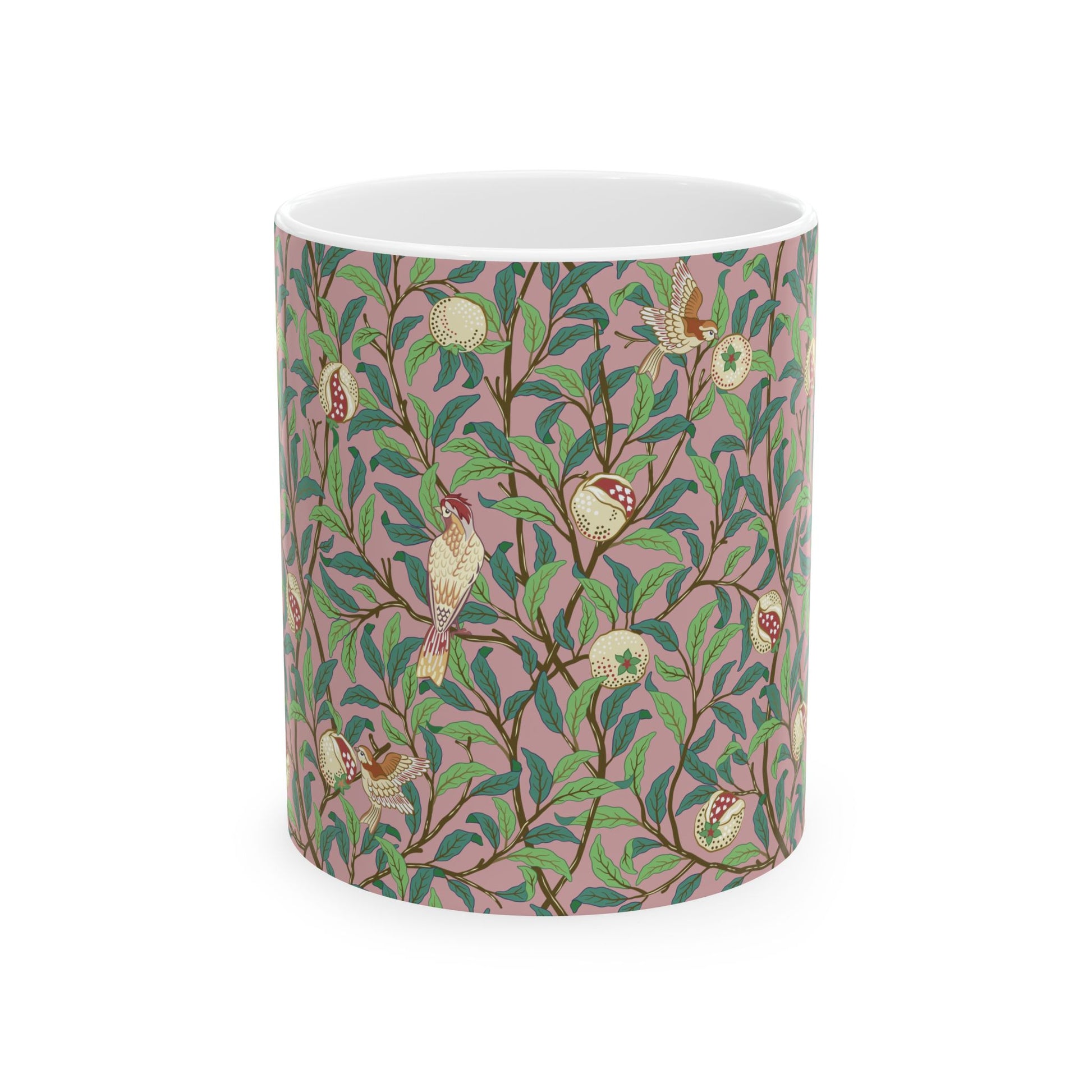 A white ceramic mug with a pink floral and pomegranate design inspired by William Morris.