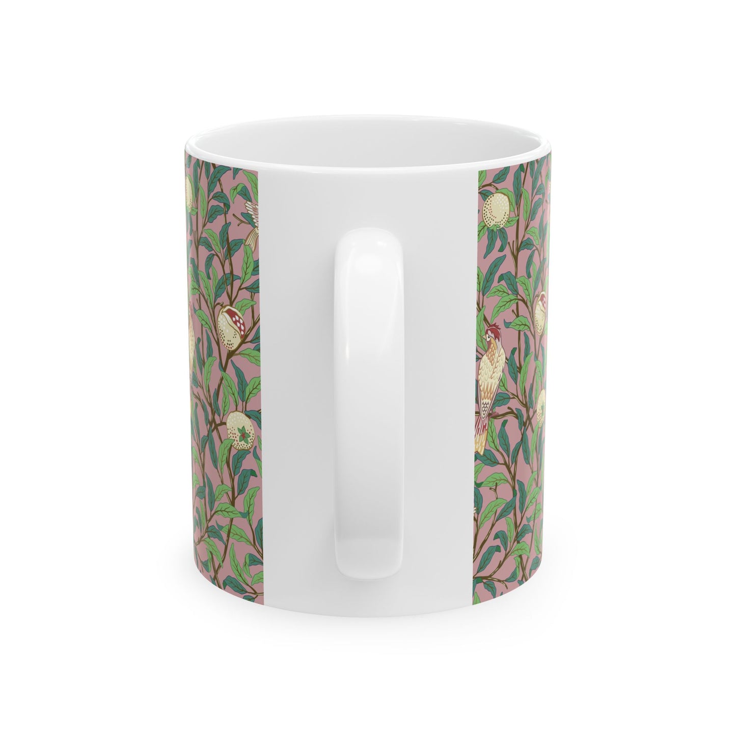 A white ceramic mug with a pink floral and pomegranate design inspired by William Morris.
