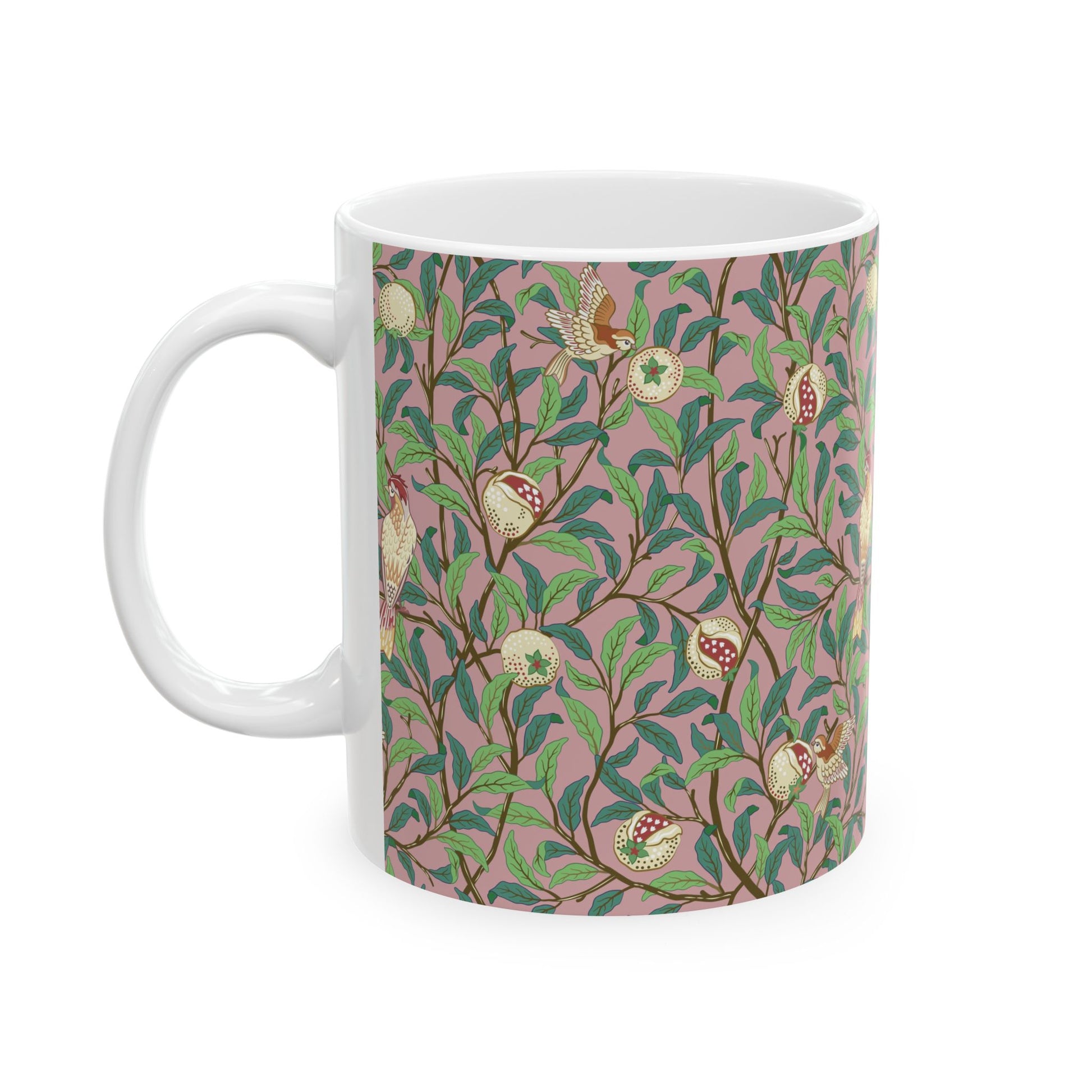 A white ceramic mug with a pink floral and pomegranate design inspired by William Morris.