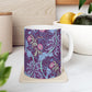 A white ceramic mug with a pink floral seaweed pattern inspired by William Morris.
