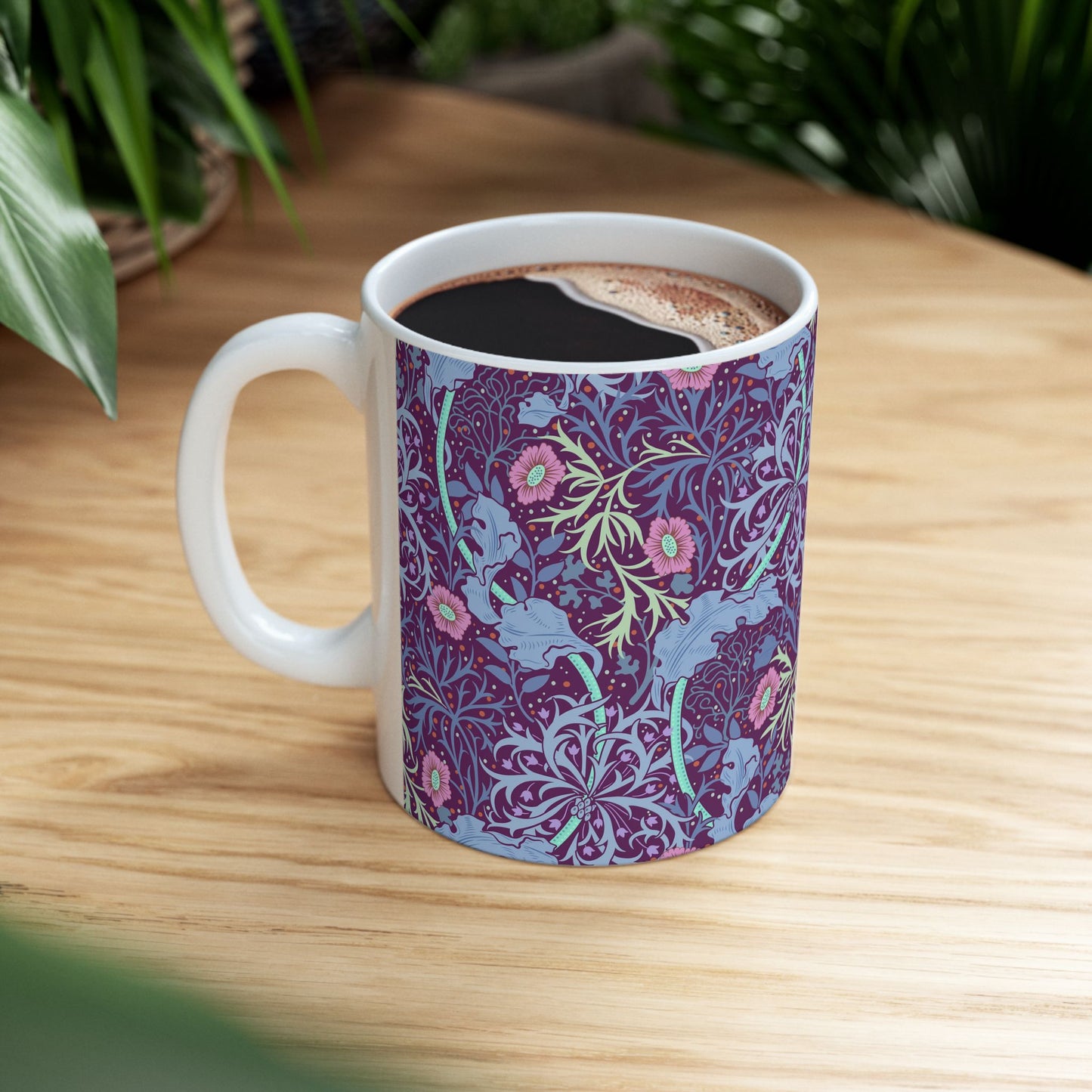 A white ceramic mug with a pink floral seaweed pattern inspired by William Morris.