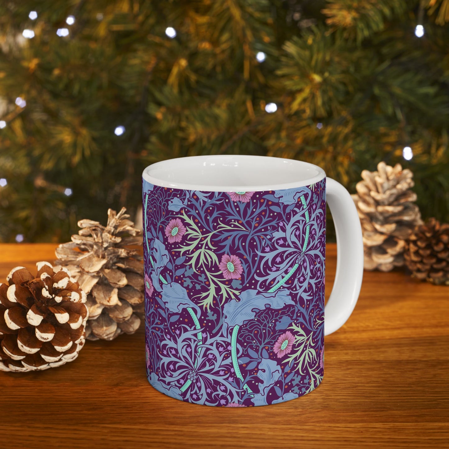 A white ceramic mug with a pink floral seaweed pattern inspired by William Morris.