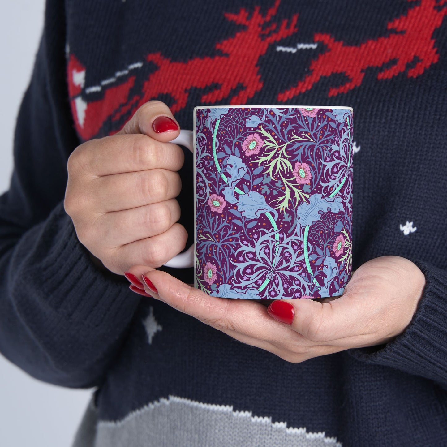 A white ceramic mug with a pink floral seaweed pattern inspired by William Morris.