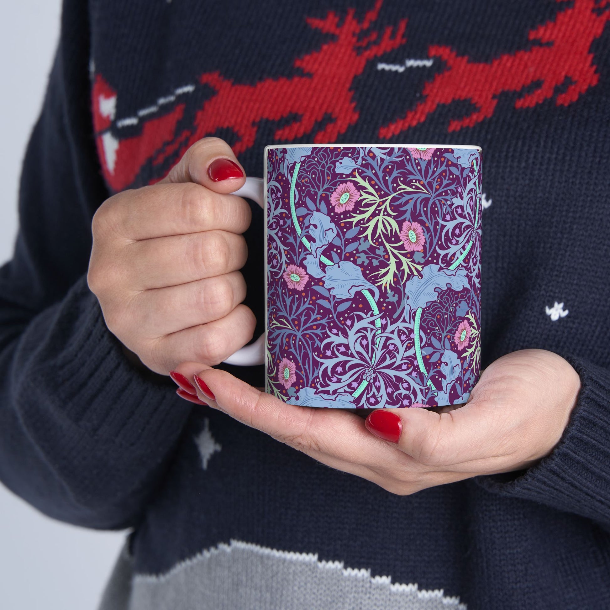 A white ceramic mug with a pink floral seaweed pattern inspired by William Morris.