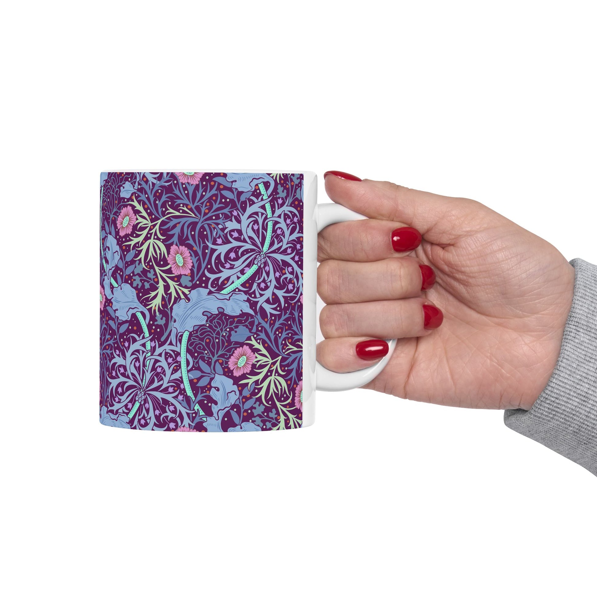 A white ceramic mug with a pink floral seaweed pattern inspired by William Morris.
