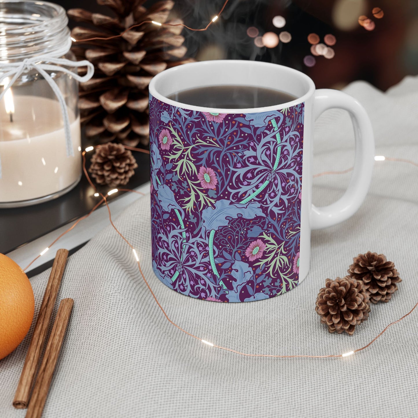 A white ceramic mug with a pink floral seaweed pattern inspired by William Morris.