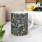 A white ceramic mug with a yellow and green floral pattern from the Collection called Seaweed inspired by William Morris.