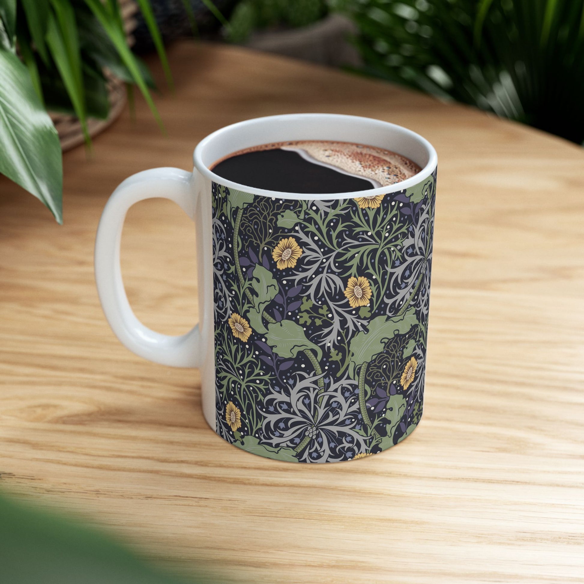 A white ceramic mug with a yellow and green floral pattern from the Collection called Seaweed inspired by William Morris.