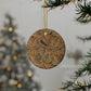 Decorative round ornament with leaf pattern hanging on a tree branch.