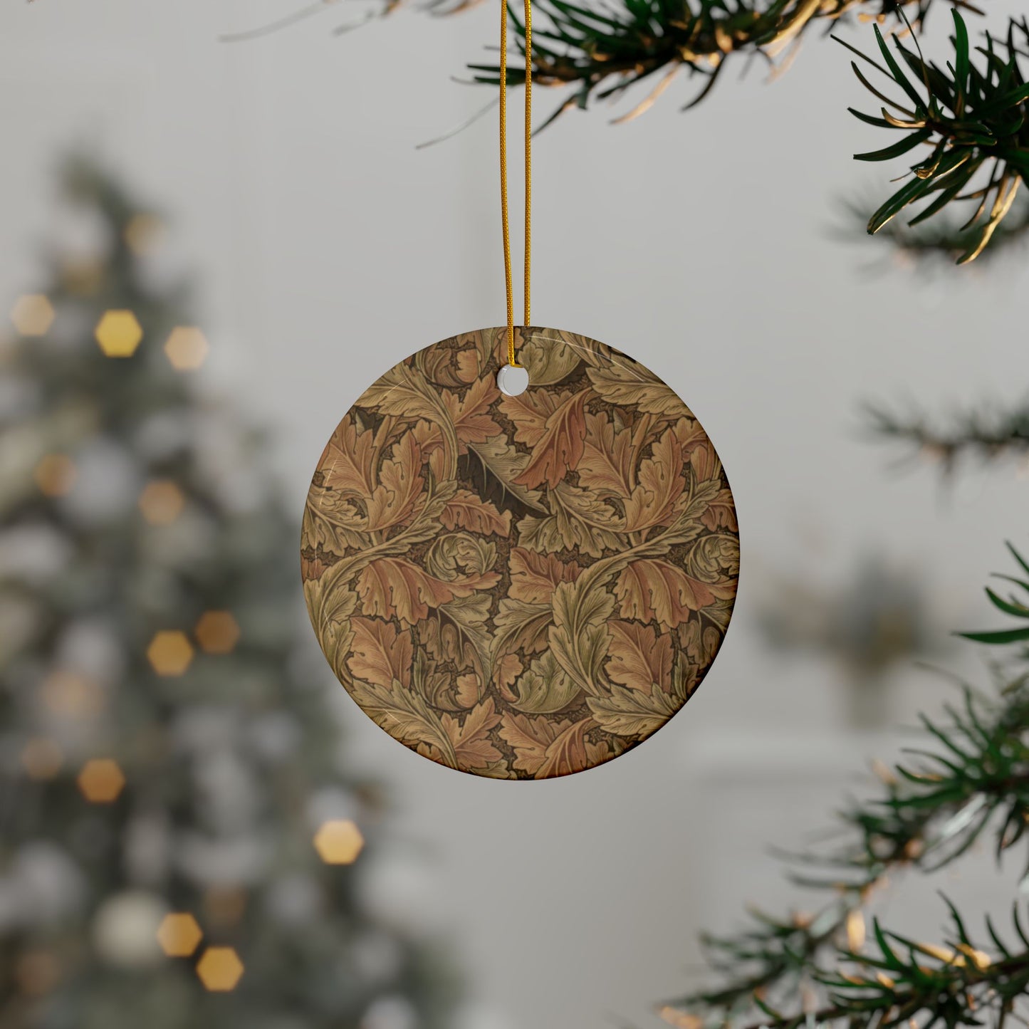 Decorative round ornament with leaf pattern hanging on a tree branch.
